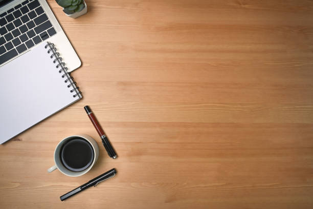 istock Mock up computer laptop, notepad and coffee cup on wooden background. 1325351522