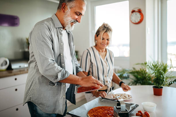 pareja preparando comida - senior adult mature adult senior couple heterosexual couple fotografías e imágenes de stock