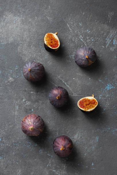 istock Organic sliced and whole fresh figs on dark background 1325354741