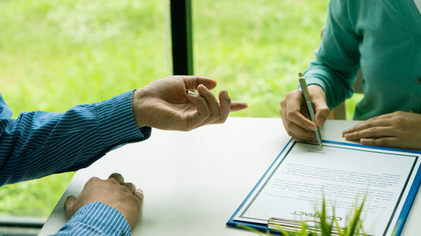 istock human hand working with documents at close-up table signature document Emphasis on female hand pen, sign official documents, contact subscribe name in declaration with legal value, contract management, good business deal, 1325354808