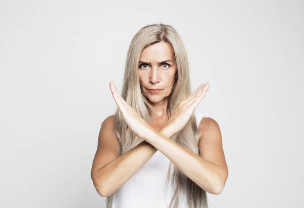 istock Elderly woman rejection expression crossing arms doing negative sign, angry face over grey background 1325355445