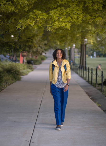 istock African American female student walking on campus with backpack and smiling 1325358805