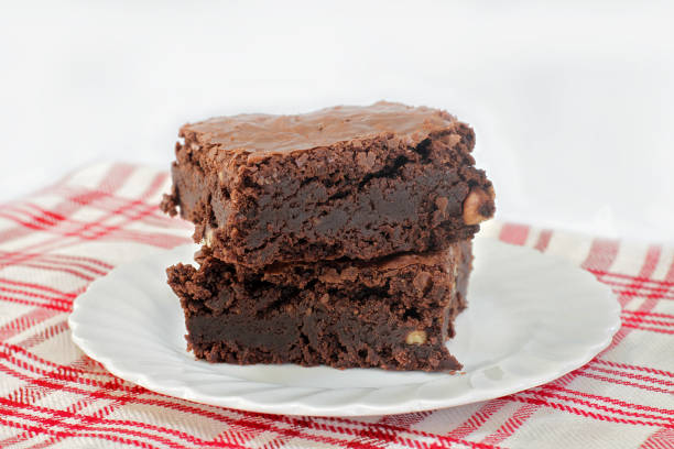 istock Two stacked chocolate fudge walnut brownies on a plate.  Shallow focus 1325359097
