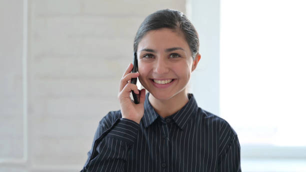 istock Cheerful Young Indian Woman Talking on Phone 1325363548