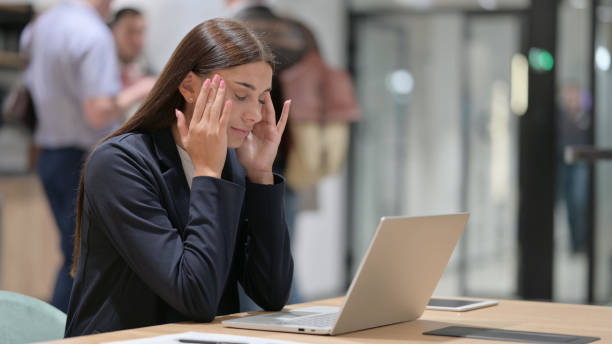Stressed Businesswoman with Headache at Work