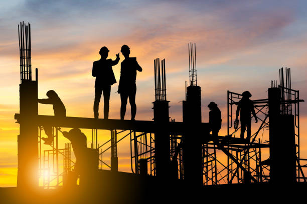 istock Silhouette of Engineer and worker on building site, construction site at sunset in evening time 1325365495