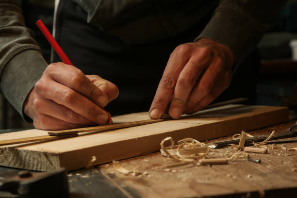 istock Carpenter measuring and marking wood in workshop 1325366997