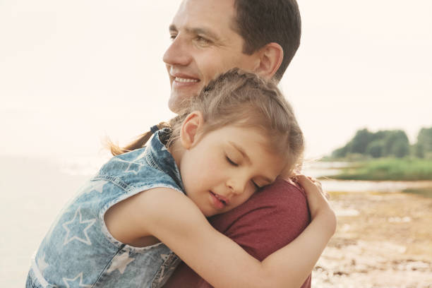 istock little happy daughter hugs daddy on sunny day 1325367999
