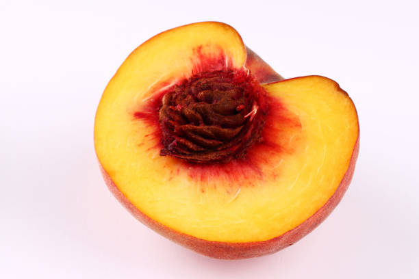 Half of peach on a white background close up