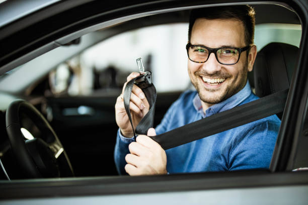 istock Happy man fastening his seatbelt before a trip by car. 1325374035