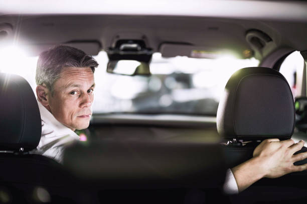 homme d’affaires adulte faisant marche arrière lors d’un voyage en voiture. - car driving men reversing photos et images de collection