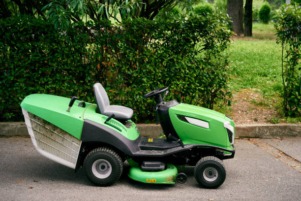 zielona kosiarka stoi na asfalcie w parku - rotary mower zdjęcia i obrazy z banku zdjęć