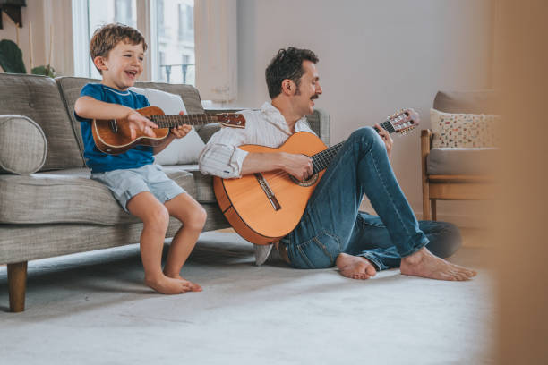 Family playing music at home Family playing music at home father and son guitar stock pictures, royalty-free photos & images