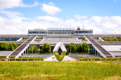 Guyancourt, France - June 18, 2021: Front view of the emblem of french automobile manufacturer Renault in front of the Technocentre, Renault research and development centre.