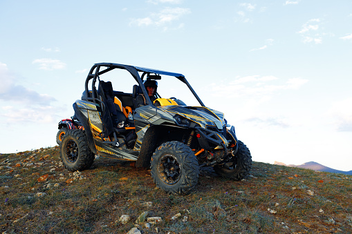 Hombre con casco sentado en quad ATV en las montañas photo