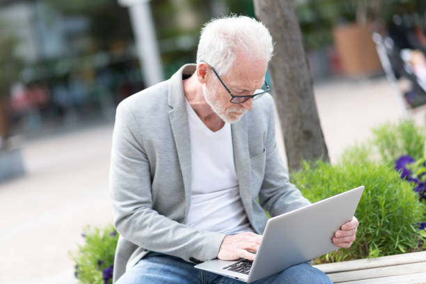 istock Mature businessman using laptop outdoors 1325381803