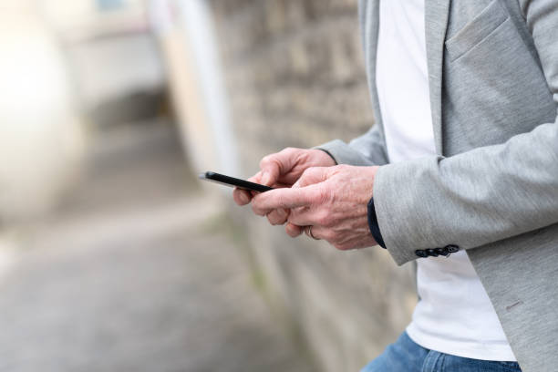 istock Man standing against a wall and using mobile phone 1325382573