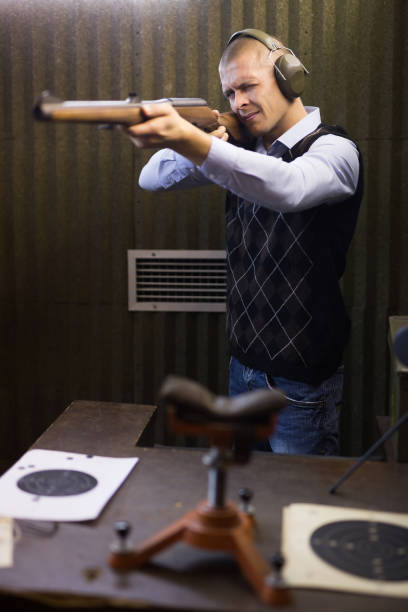 istock Confident shooter sighting in or zeroing shotgun in shooting gallery 1325384298