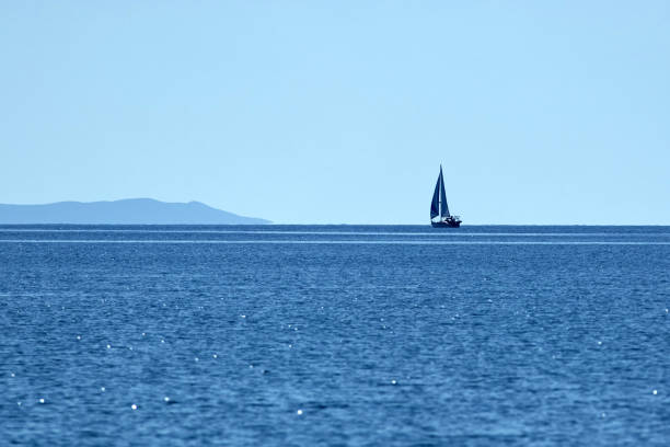 istock Sailing boat and blue ocean water with horizon. 1325384428