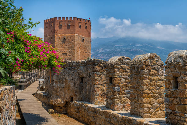 Red Tower and the fortification wall of a fortress in the Turkish city of Antalya Red Tower and the fortification wall of a medieval fortress in the Turkish city of Antalya alanya stock pictures, royalty-free photos & images