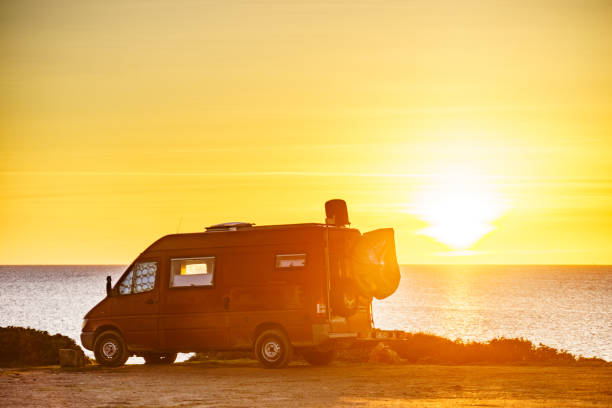 istock Camper van on beach at sunrise 1325384642
