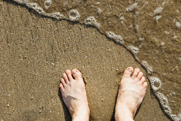 asiatische kaukasische männliche füße auf dem sand mit einer welle kommt in, im urlaub.copy space.top ansicht - 123rf stock-fotos und bilder