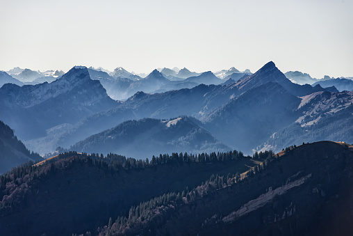 Beautiful high angle panoramic view from mountain peaks in the European alps in Switzerland. Hazy atmosphere on a beautiful autumn day.