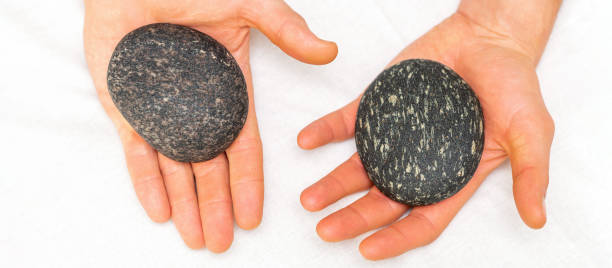 istock Two male hands with spa stones 1325388722