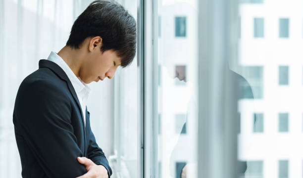 istock Tired young business man resting his head by the window 1325388884