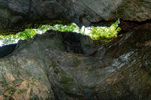 Wooden walkway leading into a narrow cave passage, next to a vertical rock wall at Pokljuka gorge in Gorenjska, Slovenia