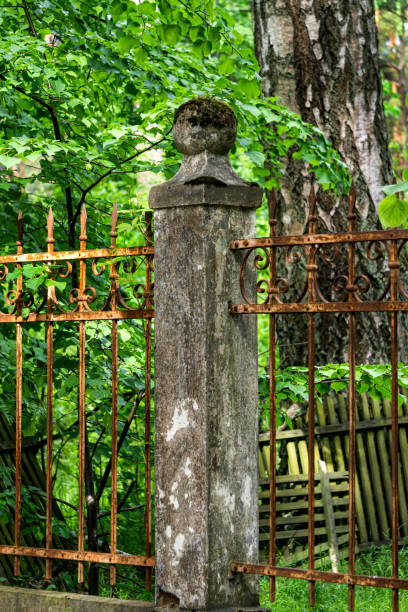 istock There is an old forged, rusty fence between the concrete pillars. 1325390422