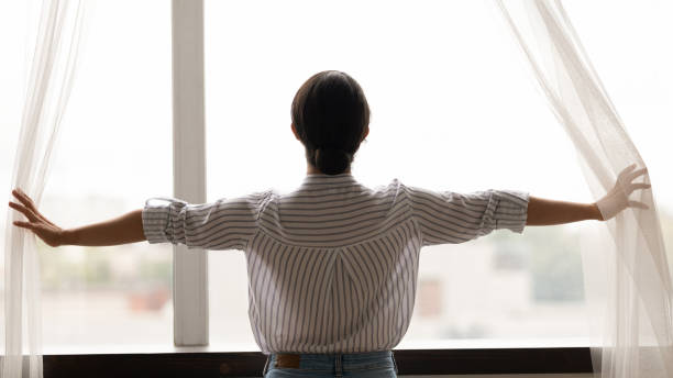 istock Indian woman open curtains in cozy home 1325391002