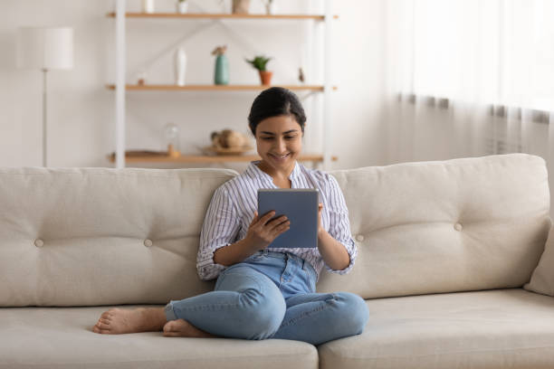 istock Happy Indian woman relax at home using modern tablet 1325391012