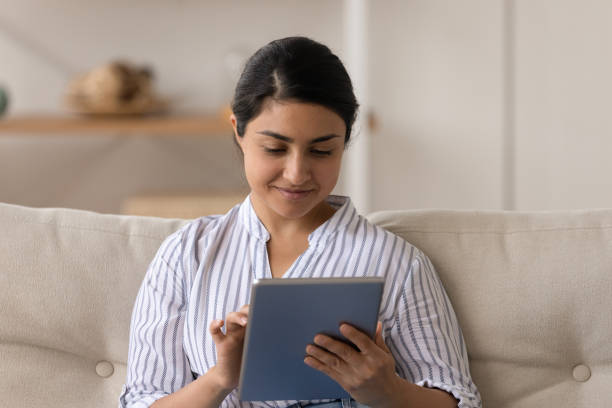 istock Happy Indian woman use tablet speak on webcam call 1325391015