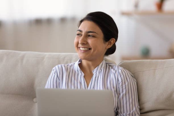 istock Smiling Indian woman work on laptop making plans 1325391022