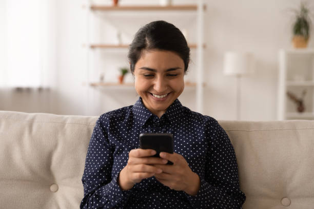 istock Smiling Indian woman use cellphone talking on webcam call 1325391053