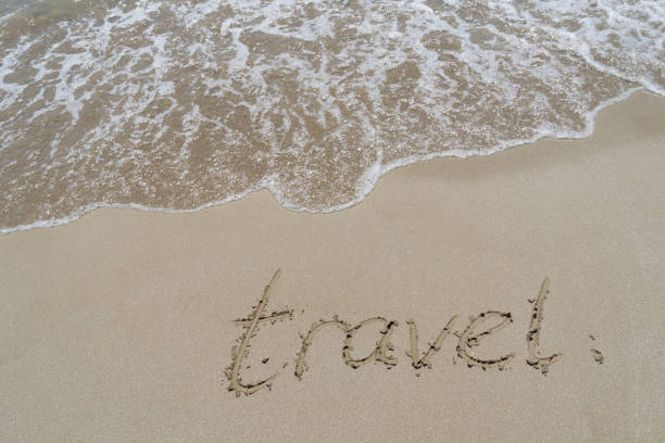 istock travel handwriting in sand on the beach 1325392544
