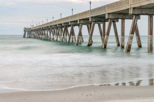 istock Blurred waves washing sandy beach and pier 1325393434