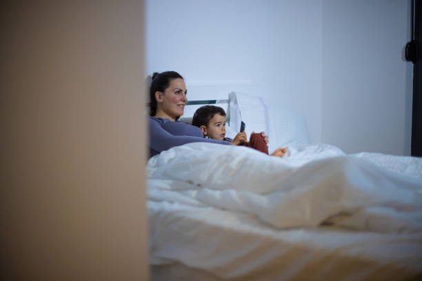 istock Mother and son watching TV at home 1325395120