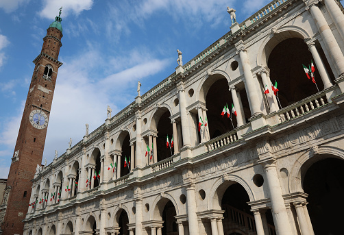 Tower of the historic monument called Basilica Palladiana in the city of Vicenza with the many flags flying during the feast of the Italian Republic