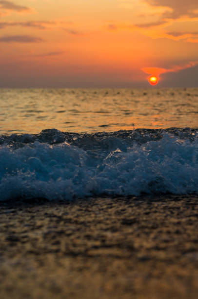 istock Amazing sea sunset on the pebble beach, the sun, waves, clouds 1325399204
