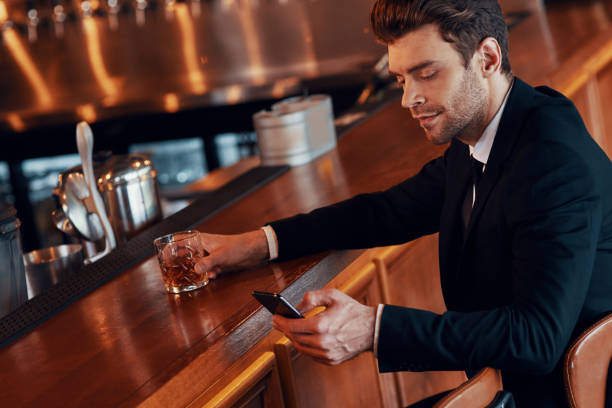 istock Handsome young man in full suit using smart phone 1325401702