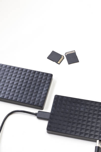 istock Storage device black external hard drive and sd Cards isolated on white background, Computer and Laptop storage concept 1325403149