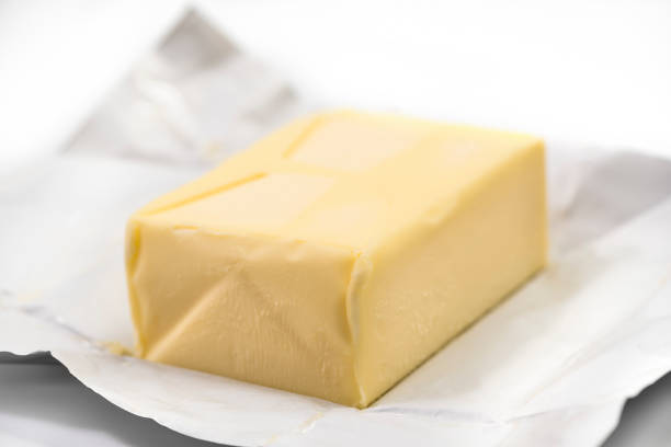 istock Traditional butter block unwrapped on white background 1325404393