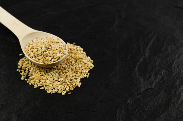istock Flax seeds in a wooden spoon on a black stone background 1325404988