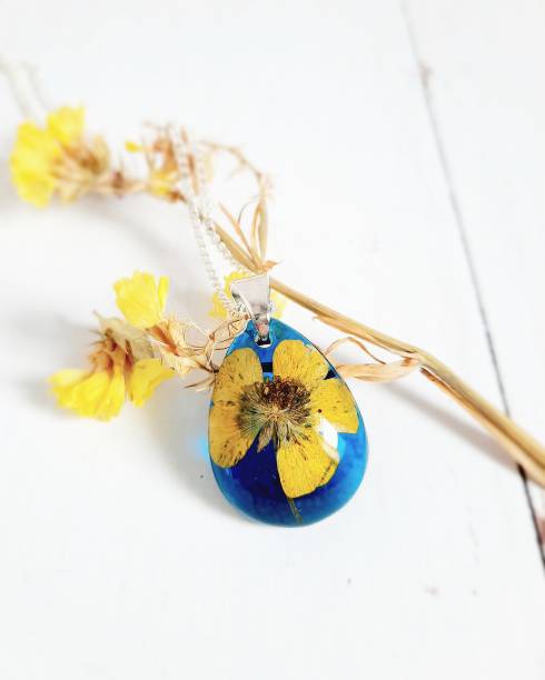 istock Blue pendant with yellow flower inside, epoxy resin, silver chain 1325405324