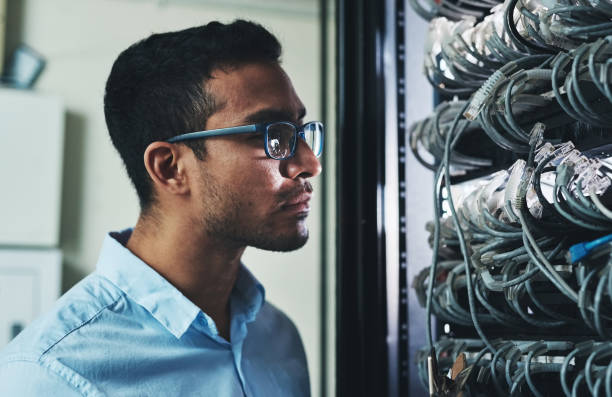 istock Shot of a handsome young technician standing alone and looking at the mainframe 1325406321