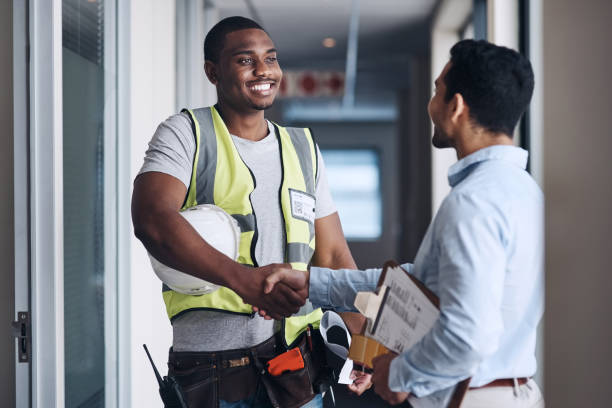 Shot of two young architects standing together and shaking hands after a discussion about the room before they renovate We'll see you on Monday! building contractor stock pictures, royalty-free photos & images