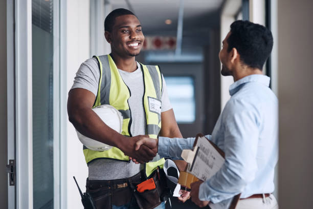 shot of two young architects standing together and shaking hands after a discussion about the room before they renovate - colleague horizontal business construction imagens e fotografias de stock