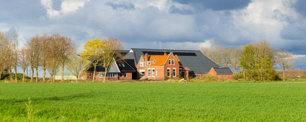 Uithuizermeeden, The Netherlands: May 2, 2021: Old farm combined with new buildings with dark clouded sky in Uithuizermeeden in Groningen in The Netherlands
